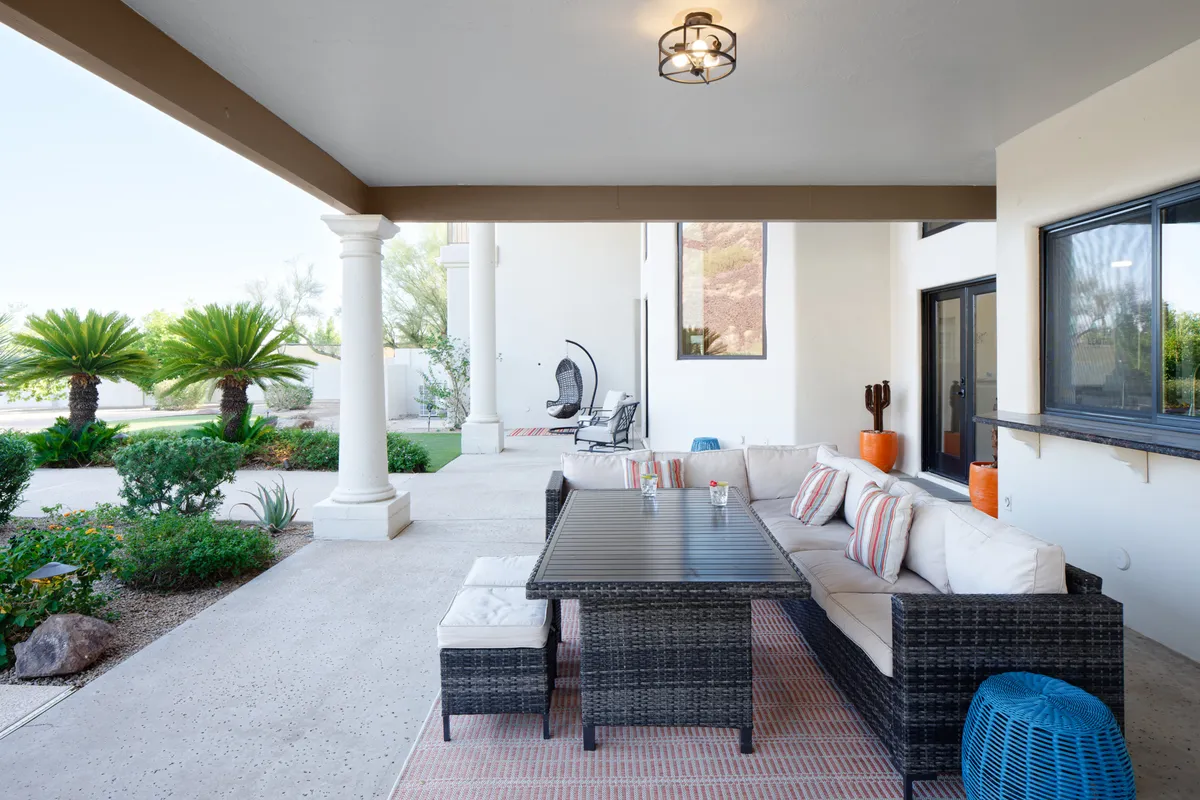 An inviting outdoor seating and dining area surrounded by palm trees and decorative cushions, perfect for sunset dinners, morning coffee, or evening gatherings under the stars.